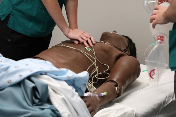 Nursing students performing CPR on a mannequin